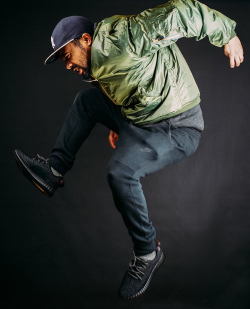 Man jump green jacket cap studio dance – Fashion & Portrait Photography