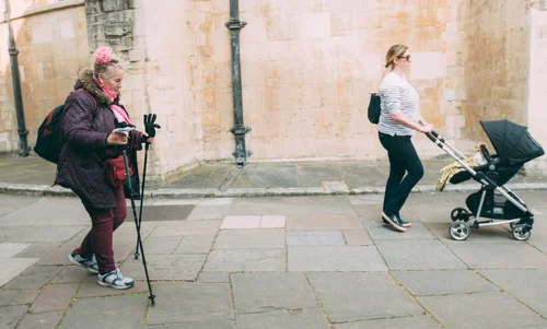 Street elderly woman walking stick pram mother – Street