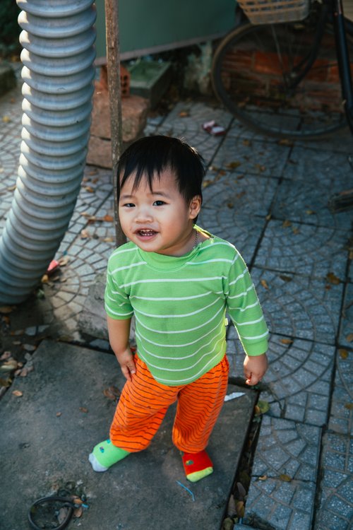 Vietnam toddler child striped top smiling street – Vietnam