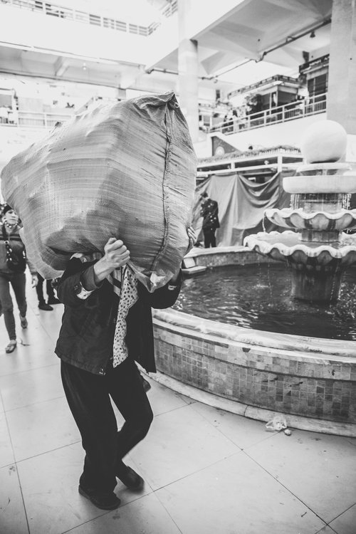 Vietnam man carrying sack black and white – Vietnam