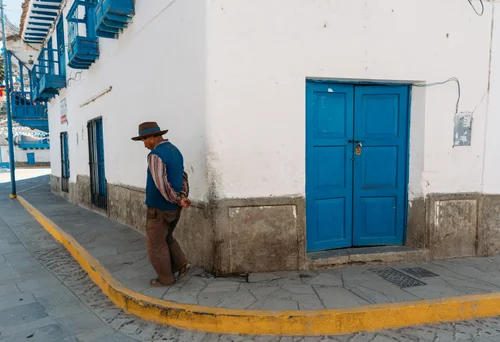 Peru man hat blue door white wall – Peru