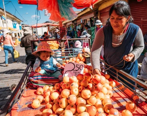 Peru market fruit vendor woman oranges child – Peru