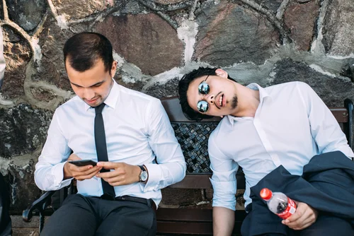 Wedding guests men suits phone relaxing bench – Wedding Photography