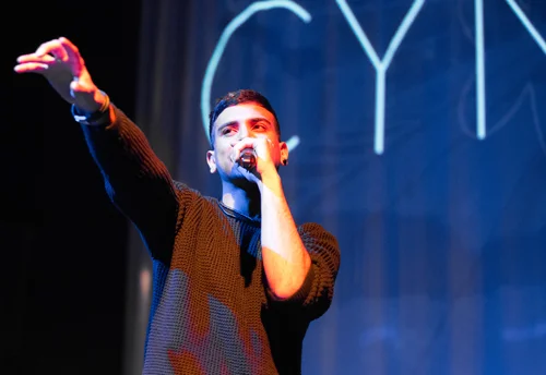 Singer man stage blue light cynical show – Cynical headliner show