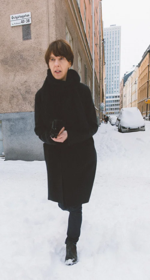 Stockholm woman black coat snow street winter – Stockholm