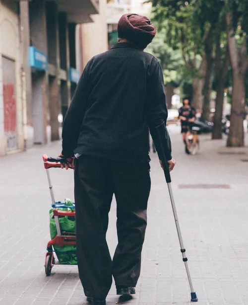 Barcelona elderly man crutches walking street trolley – Barcelona