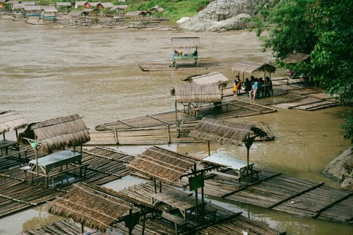 Philippines river bamboo rafts huts brown water – Philippines