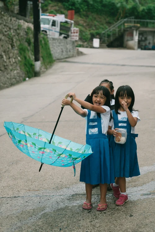 Philippines two girls umbrella children blue dresses – Philippines