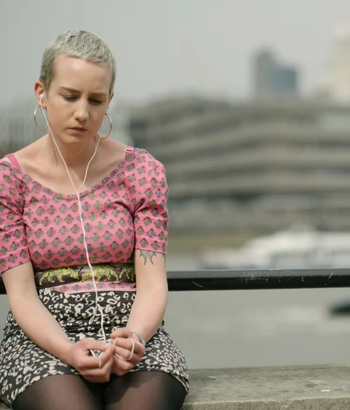 Woman headphones pink top pensive river thames – Street